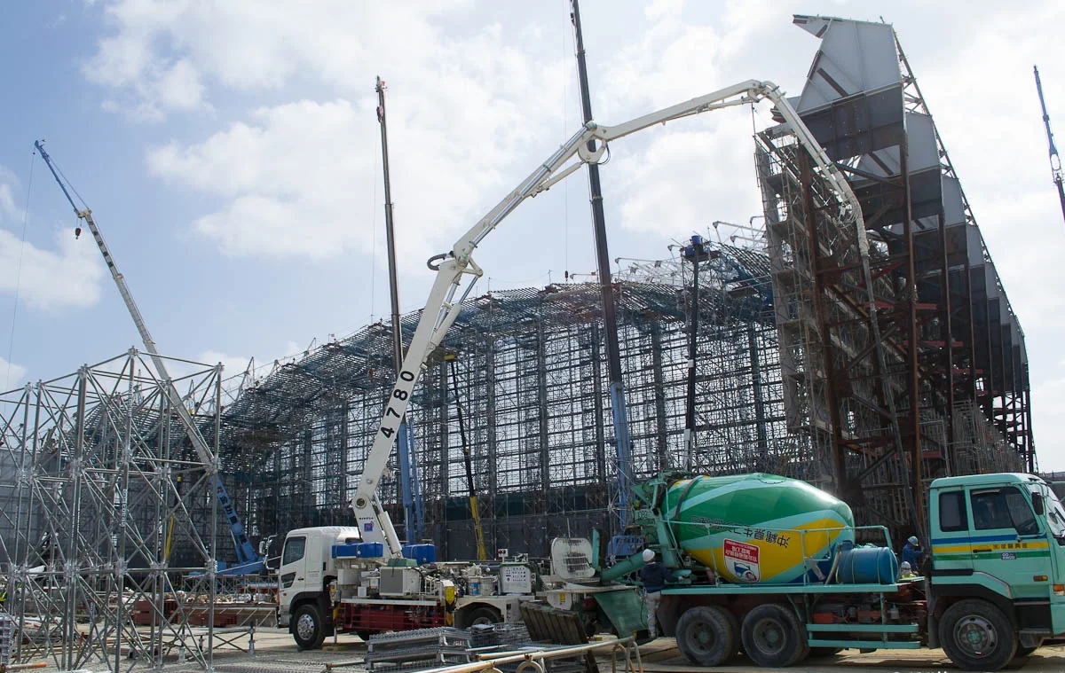 Active construction site with concrete placement and structural work
